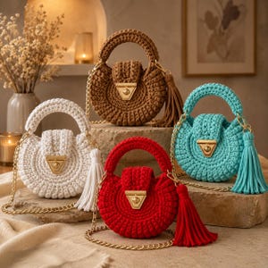 May include: Four round crochet handbags in white, brown, red, and turquoise. Each bag features a top handle, a gold-tone metal clasp on the front flap, a matching long tassel, and a gold-tone chain shoulder strap for a structured appearance.