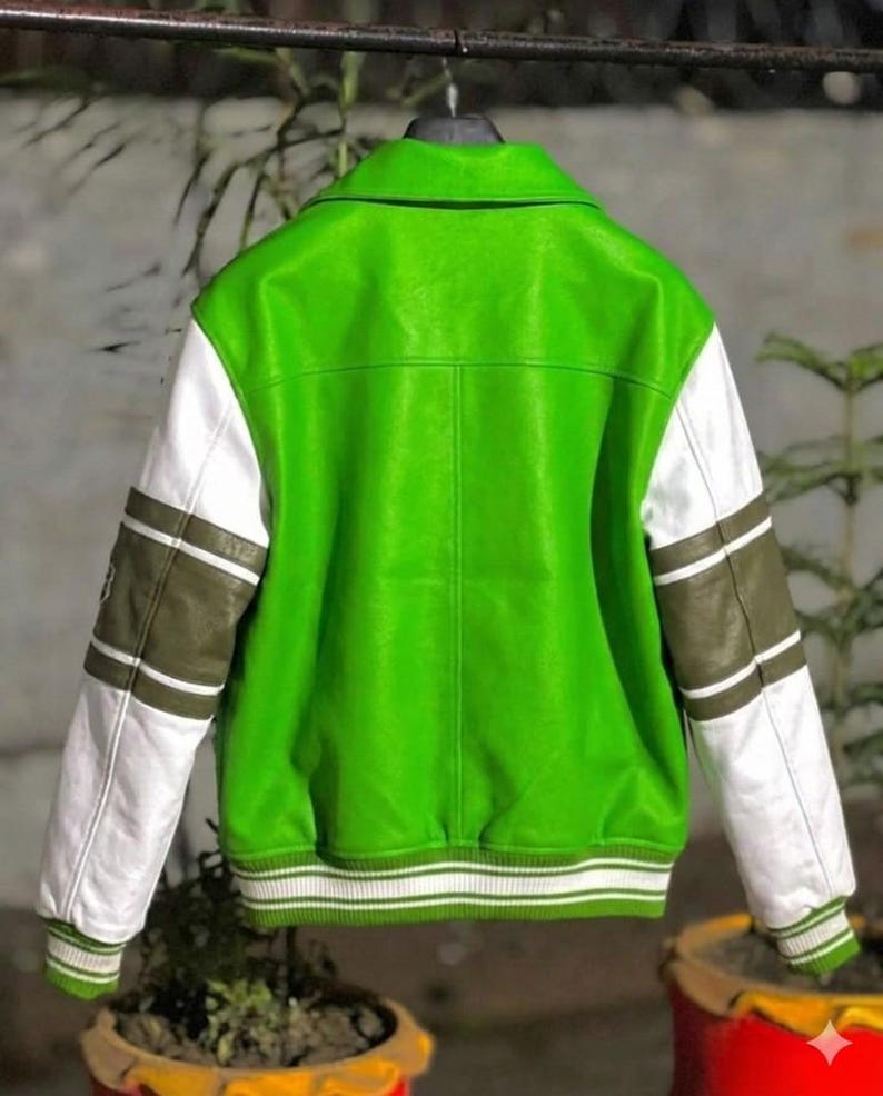 May include: A bright lime green varsity jacket featuring white sleeves with olive green horizontal stripes. The jacket includes a classic collar, a ribbed hem, and ribbed cuffs, all detailed with white and green striped patterns on the edges.