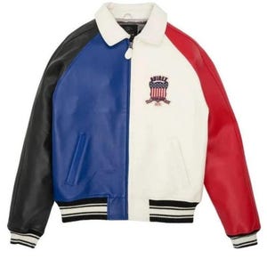 May include: A color-blocked jacket featuring a white collar, a black sleeve, a blue front panel, a white front panel, and a red sleeve. The jacket has a front zipper closure, striped ribbed cuffs and hem, and an Avirex shield patch on the chest.