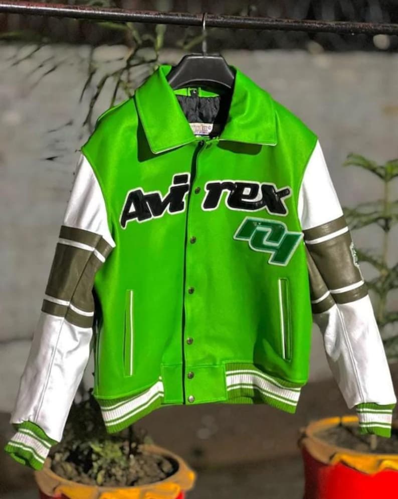 May include: A bright green varsity jacket featuring white and olive green sleeves with striped ribbed cuffs. The front displays the text Avi rex in black lettering with a white outline, alongside a green and white number 24 patch on the chest.