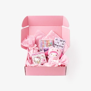 May include: A pink gift box filled with various items, including a Hello Kitty book, a plush toy, and a set of colorful lip glosses. The box is lined with pink tissue paper and features a bow.