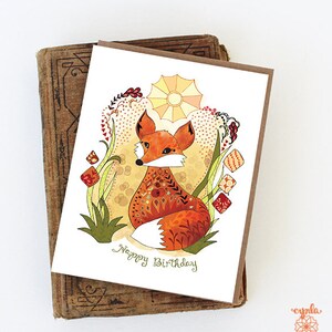 greeting card kid birthday theme red fox greeting card with a colorful illustration of a fox sitting in a field of flowers. The card has the text "Happy Birthday" on the front. art by Cindy LaColla. ©cynla
