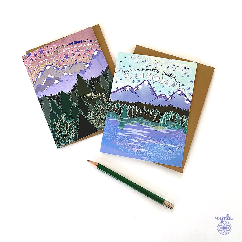 Greeting Card mountains lake forest adventure birthday camping card trees stars wilderness outdoor lover card hiker May include: Two greeting cards with a mountain and forest scene. The card on the left has a dark background with gold stars and the text "Hope your year is filled with adventures". The card on the right has a light blue background with the text "Have an incredible birthday".