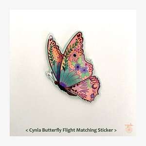 Op de afbeelding: Een kleurrijke vlindersticker met ingewikkelde bloempatronen in roze, paars, groen en blauw. De sticker heeft een heldere rand en de tekst "Cynla Butterfly Flight Matching Sticker" is zichtbaar.