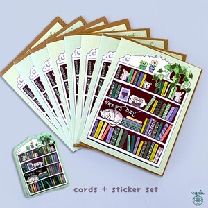 May include: A set of greeting cards and a sticker featuring a whimsical bookshelf design. The cards have a light green background with a brown border. The bookshelf is filled with colorful books, a sleeping cat, and the words "Happy Day".