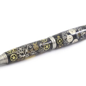May include: A unique pen with a black and silver body, adorned with intricate clock gears in gold and silver. The pen features a silver tip and accents, showcasing a steampunk aesthetic. The design includes watch faces and detailed mechanical elements.