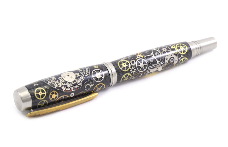 May include: A pen with a black and silver body, adorned with intricate clockwork gears in gold and silver. The pen features a silver tip and a gold-colored clip, showcasing a steampunk aesthetic.