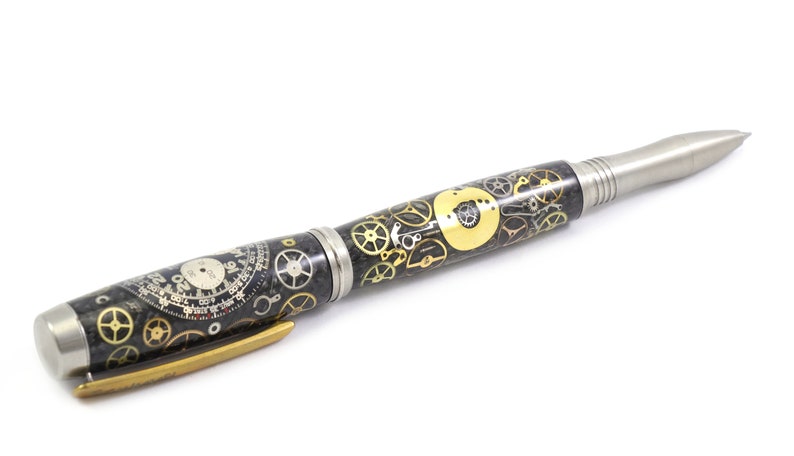 May include: A detailed pen with a steampunk design. The pen features a black and silver body with gold-colored gears and clock faces. The pen has a silver tip and a gold-colored clip.
