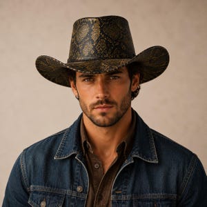 May include: A cowboy hat featuring a dark brown and black snakeskin pattern throughout the crown and wide brim. The hat has a structured, tall crown and a curved brim, showcasing a detailed reptilian texture across the entire surface.