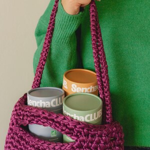 May include: A white ceramic mug with a black handle and the text "But First, Coffee" in a black, handwritten-style font. The mug is on a white surface.