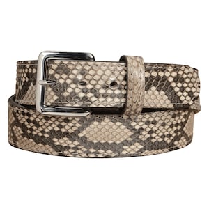 May include: A snakeskin belt with a silver-colored buckle. The belt features a pattern of gray, black, and tan scales. The buckle is a square shape with a single prong.