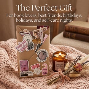 Op de afbeelding: Een bruin papieren cadeauzakje versierd met diverse stickers met boeken als thema, waaronder een lezend skelet, een 'Midnight Readers Book Club'-embleem en de tekst 'Smut Loading'. Daarnaast staat een amberkleurige glazen kaars en een droogboeket.