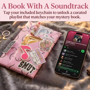 Op de afbeelding: Een roze ingepakt boek versierd met stickers, waaronder een roze muzieknoot, een lezend skelet en de tekst SMUT UNIVERSITY en HELLO I'M READING, SO DON'T BOTHER ME. Een smartphone toont een afspeellijst genaamd SOUNDTRACK FOR MYSTERY READS.