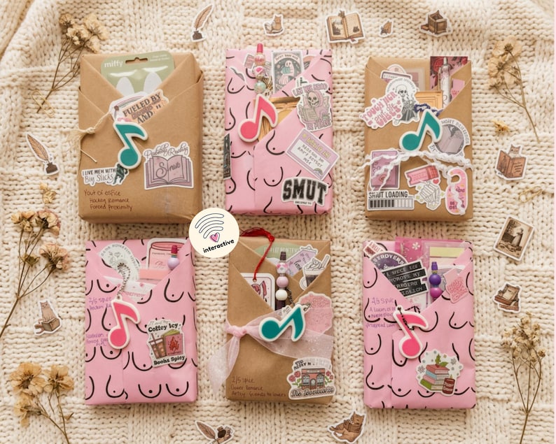 Op de afbeelding: Zes rechthoekige pakketjes verpakt in bruin of roze papier, versierd met diverse stickers, muzikale noot-bedeltjes en handgeschreven tekst. De pakketjes zijn gerangschikt in twee rijen van drie en bevatten verschillende grafische ontwerpen.