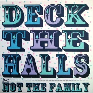 May include: Square print with the words "DECK THE HALLS NOT THE FAMILY" in large, stylized letters. The letters are in shades of blue, teal, and purple with a black outline, set against a white background with pink and blue polka dots.