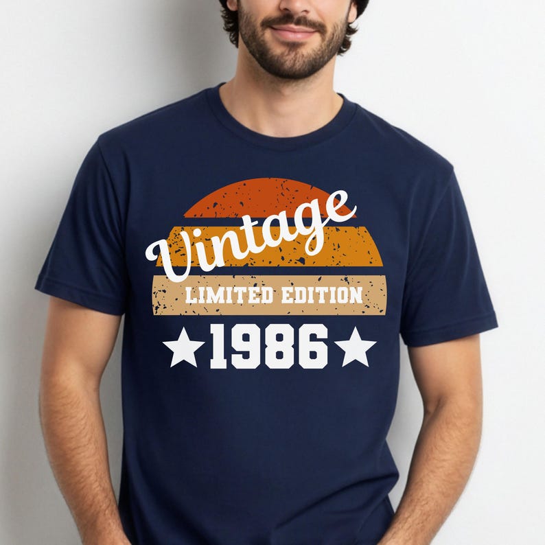 Op de afbeelding: Marineblauw T-shirt met een vintage design. Het ontwerp toont het woord "Vintage" in een scriptlettertype, boven een retro zonsondergangafbeelding, de tekst "LIMITED EDITION" en het jaar "1986" met sterren. Een klassiek T-shirt.