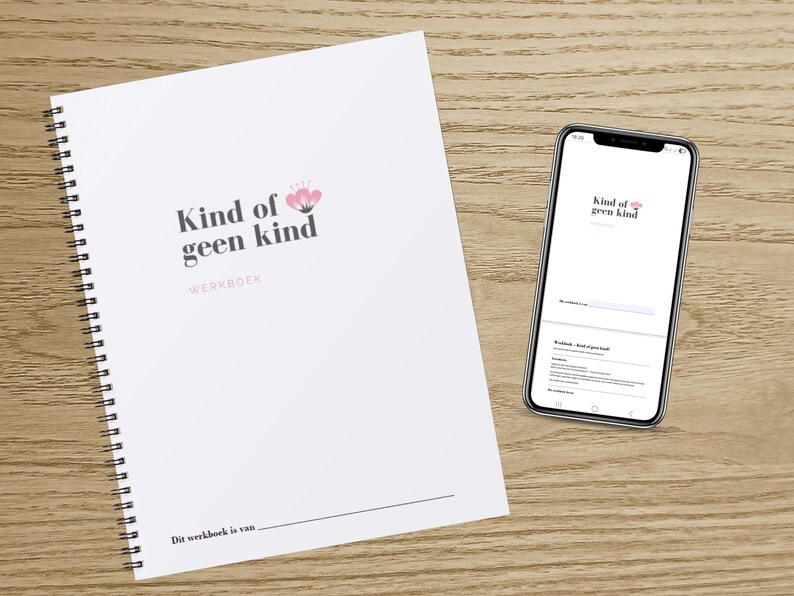 May include: A white spiral-bound workbook and a smartphone on a wooden surface. The workbook cover features the text "Kind of geen kind" with a pink floral design. The smartphone displays the same text and design.