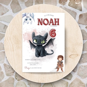 May include: A birthday invitation featuring a black dragon with green eyes and wings, the name "NOAH" in red, and the number "6". The invitation includes the text "FLY ON OVER" and event details. The invitation is on a wooden surface.