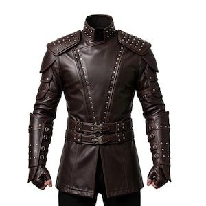 May include: A brown leather jacket with studded accents on the shoulders, sleeves, and collar. The jacket features a belted waist and decorative panels on the upper arms. The design includes a high collar and a series of small metal studs.