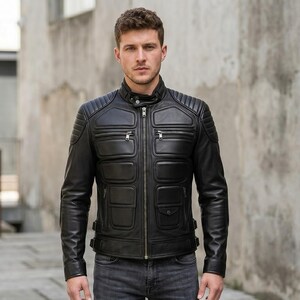 May include: A black leather jacket featuring a mandarin collar with a snap button, a full-length front zip, and padded paneling on the chest and shoulders. The jacket includes multiple zipped pockets and adjustable side straps at the waist.