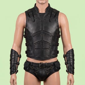 May include: A black leather chest armor vest featuring segmented panels, metallic rivets, and adjustable buckle straps at the shoulders and sides. The set includes matching black leather forearm bracers and a belt with attached pouches.