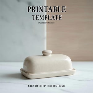 Puede incluir: Una mantequera de cerámica beige con tapa y un pequeño pomo. El plato es rectangular con bordes redondeados y se asienta sobre una base a juego. El texto "PRINTABLE TEMPLATE" y "STEP BY STEP INSTRUCTIONS" son visibles.