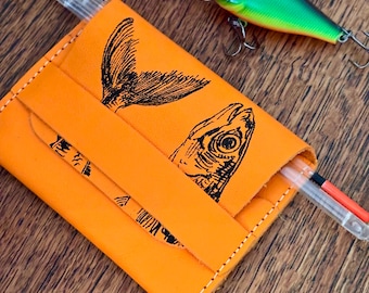 アーティストが描いた魚のデザインが施された、手作りの革製カードホルダー。