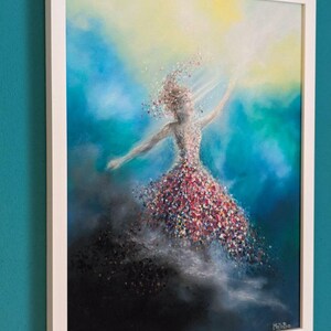May include: A framed painting depicting a figure in a dress composed of colorful, scattered petals or confetti, reaching toward a bright yellow light. The background transitions from deep black at the bottom to vibrant blue and teal hues.