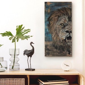 Peut inclure: Une toile murale rectangulaire représentant une peinture détaillée de tête de lion avec une crinière brune et la gueule ouverte, sur un fond texturé bleu et brun. L'œuvre présente des coups de pinceau visibles et une signature dans le coin.