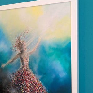 May include: A framed painting featuring a figure composed of colorful, scattered paint flecks against a vibrant blue and yellow background. The figure appears to be in motion, with particles trailing from the body into a bright, light-filled area.
