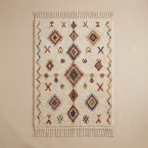 Top-down view of ivory Berber rug with diamond geometric motifs and tribal symbols, displaying full pattern layout and handwoven craftsmanship