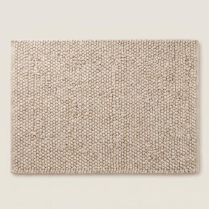 Top view of neutral chunky knit style rug with sculptural braided texture