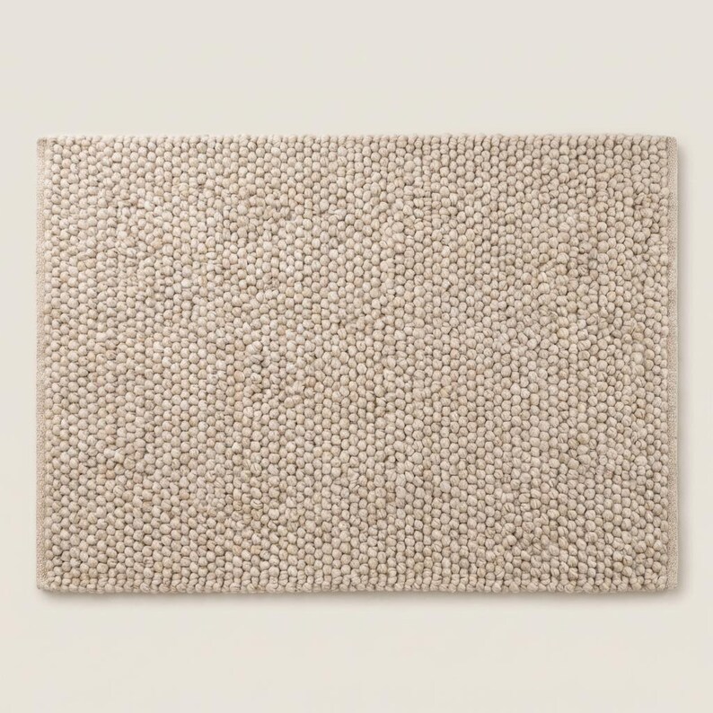 Top view of neutral chunky knit style rug with sculptural braided texture
