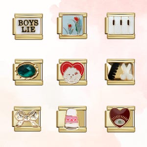 May include: Nine gold-toned charm bracelets with various designs. The charms include a white rectangle with "BOYS LIE" text, a floral scene, a piano keyboard, a green gemstone, a dog in a heart, a comb and bunny, a bow, a nail polish bottle, and an eye in a heart.