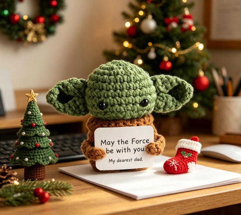 May include: A crocheted green character doll with large ears holds a sign that reads "May the Force be with you. My dearest dad." A small crocheted Christmas tree and red stocking are also present.