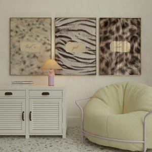 May include: Three rectangular wall art prints featuring animal fur patterns in shades of beige, brown, and black. Each print has a central torn paper element with the text God's, got, and me. displayed in a cursive font across the three frames.