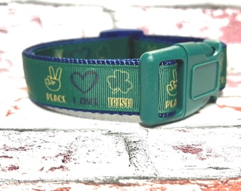 May include: Green dog collar with a blue trim and a teal buckle. The collar features the words "PEACE, LOVE, IRISH" with peace signs, hearts, and shamrocks in gold.