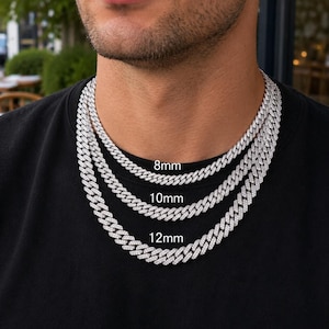 Op de afbeelding: Drie zilverkleurige cuban link kettingen met ingebedde heldere stenen. De kettingen zijn gelaagd en gelabeld met hun respectievelijke breedtes van 8mm, 10mm en 12mm. Elke ketting toont een herhalend patroon van in elkaar grijpende schakels.