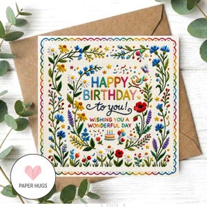 May include: A square greeting card with a cream background featuring colourful embroidered-style floral borders. The text reads HAPPY BIRTHDAY TO YOU! WISHING YOU A WONDERFUL DAY, accompanied by a small cake, a bird, and a butterfly illustration.