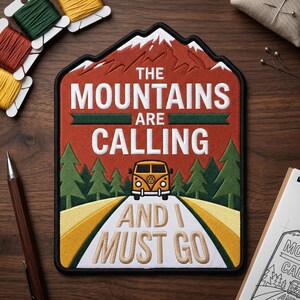 May include: Embroidered patch with a mountain and road design. The text "THE MOUNTAINS ARE CALLING AND I MUST GO" is featured. The patch includes a yellow van, green trees, and a red mountain.