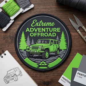 May include: Round embroidered patch with the text "Extreme Adventure Offroad" and a green Jeep. The patch features a black background with green trees and a gray border. Additional items include thread spools, scissors, and a sketch.