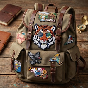 May include: An olive green canvas backpack with brown leather details and patches. Patches include a tiger wearing sunglasses, a bear, and state emblems. The backpack has multiple pockets and adjustable straps, ideal for travel or daily use.
