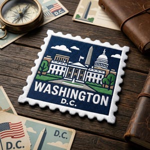 May include: A navy blue patch with a white border featuring a Washington D.C. design. The patch depicts the White House, the Capitol Building, and the Washington Monument. Other items include postcards, a compass, and a leather-bound journal.
