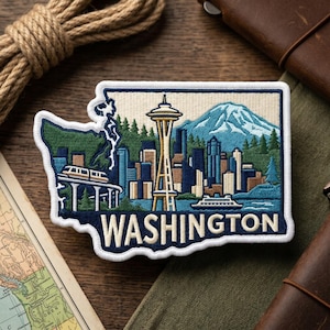 May include: Embroidered patch in the shape of Washington state, featuring the Seattle skyline, Space Needle, and a mountain. The patch is bordered in white with the word "WASHINGTON" in white lettering.