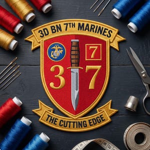 May include: A red, gold, and black embroidered patch with the text "3D BN 7TH MARINES" and "THE CUTTING EDGE." The patch features a dagger, the number 3 and 7, and a Marine Corps emblem. Sewing supplies, including thread and needles, surround the patch.