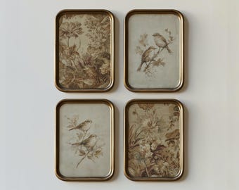 May include: A set of four rectangular wall frames with rounded corners and a metallic bronze finish. Two frames contain sepia-toned illustrations of birds perched on branches, while the other two feature intricate floral patterns in brown tones.