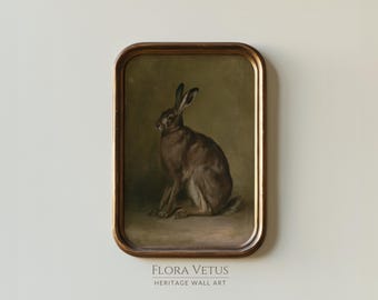 May include: A rectangular wall art piece featuring a painting of a brown hare sitting in profile against a muted olive green background, enclosed in a dark brown wooden frame. The text FLORA VETUS HERITAGE WALL ART is printed below the frame.