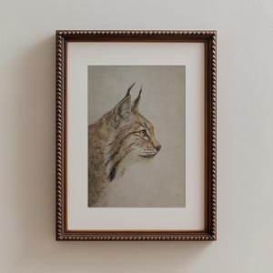 Vertical framed version with wide mat around the bobcat portrait, emphasizing generous negative space.