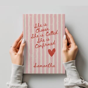 May include: A personalized journal with a pink and cream striped cover. The cover features the text "She is Chosen, She is Called, She is Confirmed" in red script, a red heart, and the name "Samantha".
