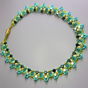 Op de afbeelding: Een turquoise, gouden en zwarte kralenketting met een geometrisch patroon. De ketting is gemaakt van kleine, gefacetteerde kralen en heeft een sluiting.